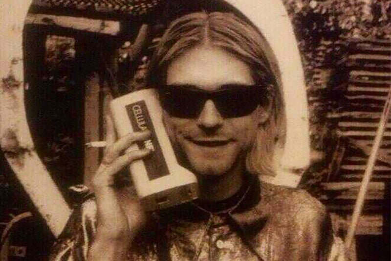 Kurt Cobain on his cell phone wearing black sunglasses