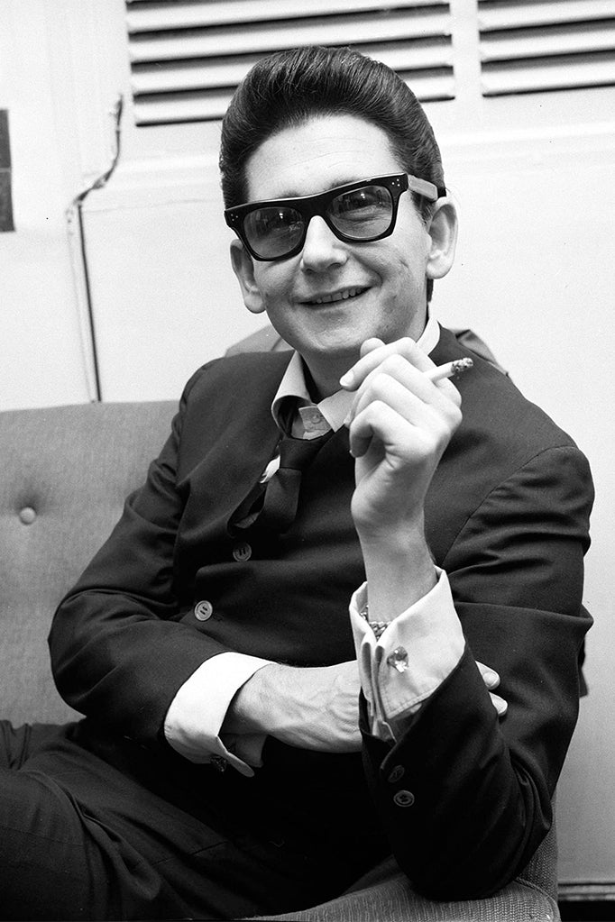 Roy Orbison wearing thick black frames smoking a cigarette