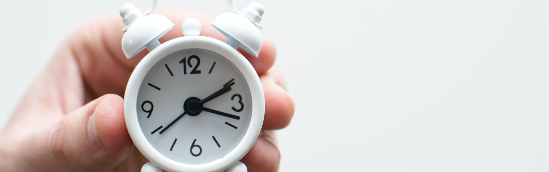 hand holding a small clock 