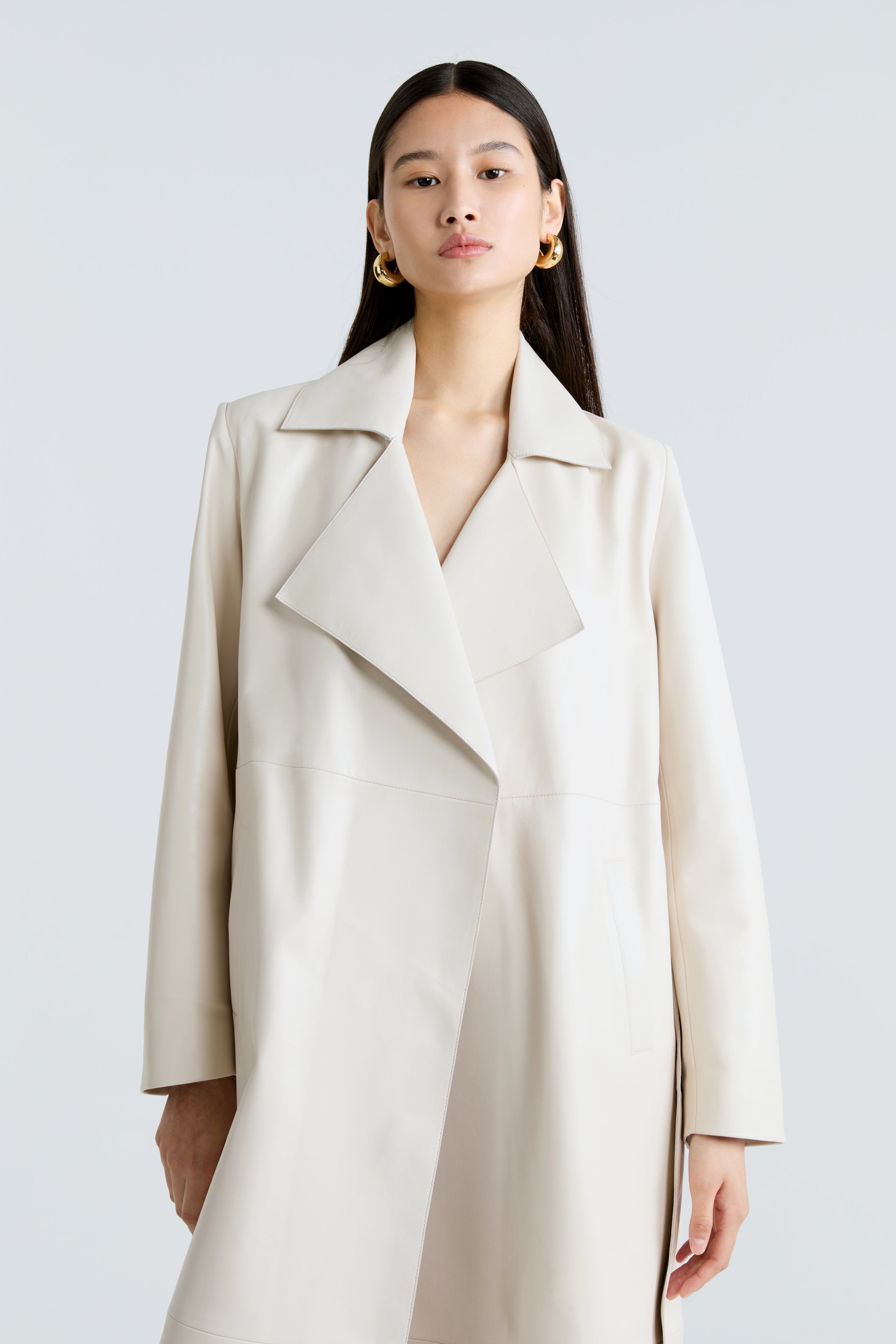 Model is wearing Nour Hammour's Amina Ivory Leather Trench Coat - Open Close Up