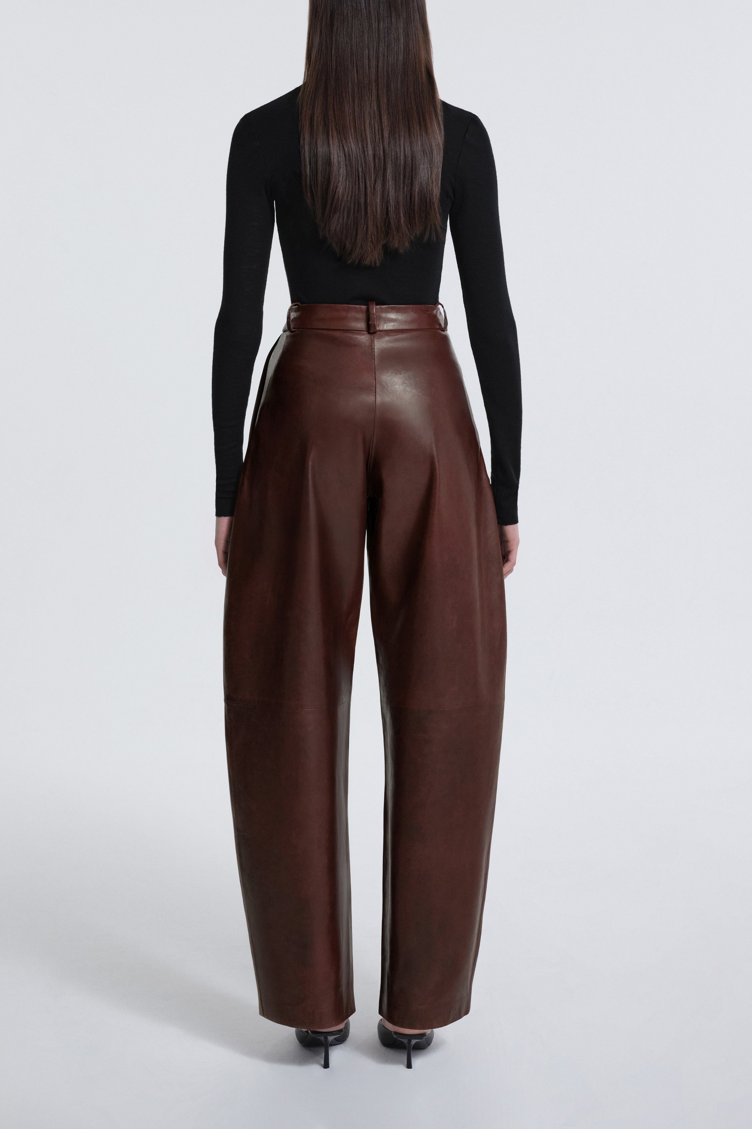 Model is wearing Nour Hammour Barrel Pants in Leather Auburn Patina - Back