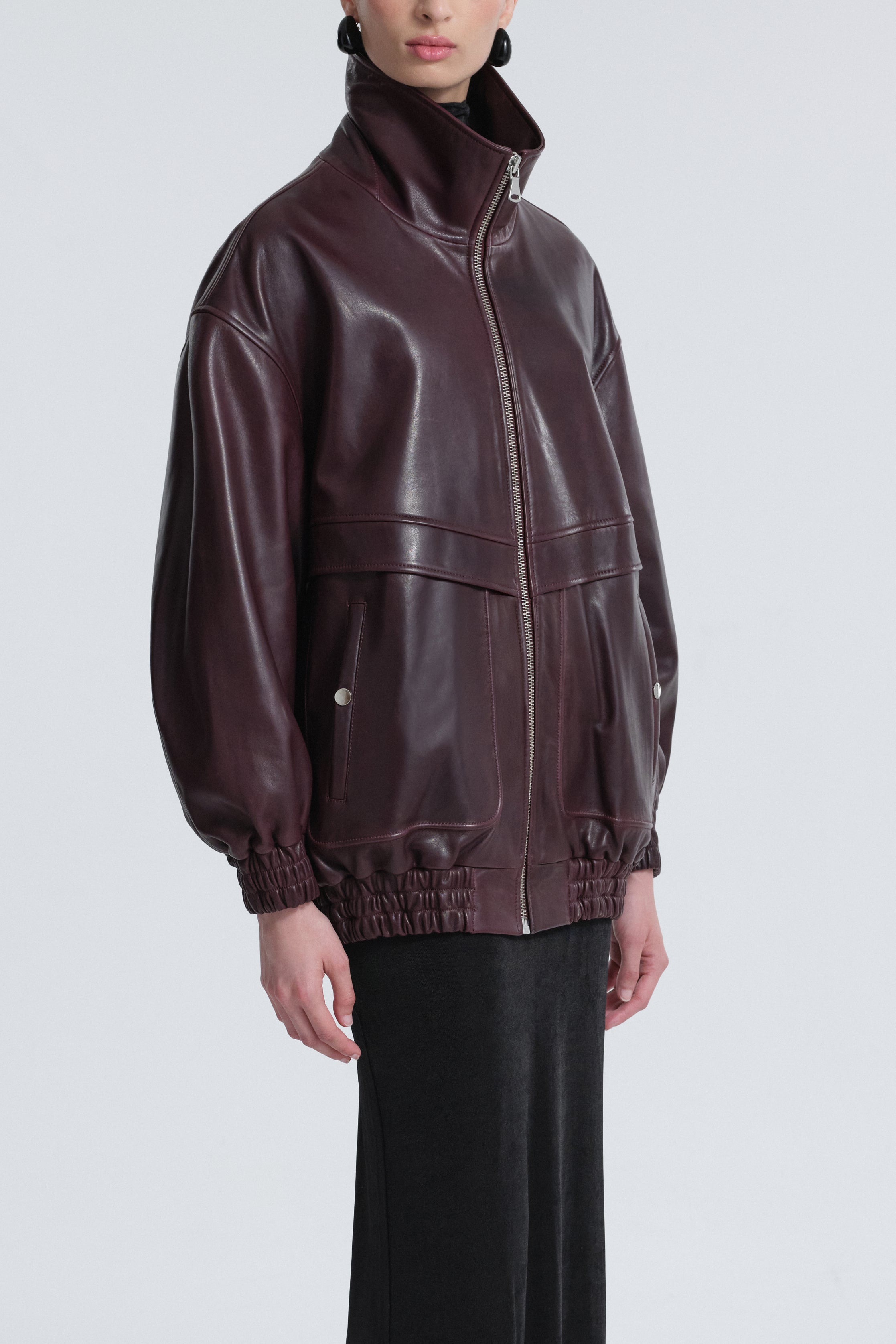 Model is wearing Nour Hammour Beck Leather Bomber Jacket Dark-Plum - Three Quarters