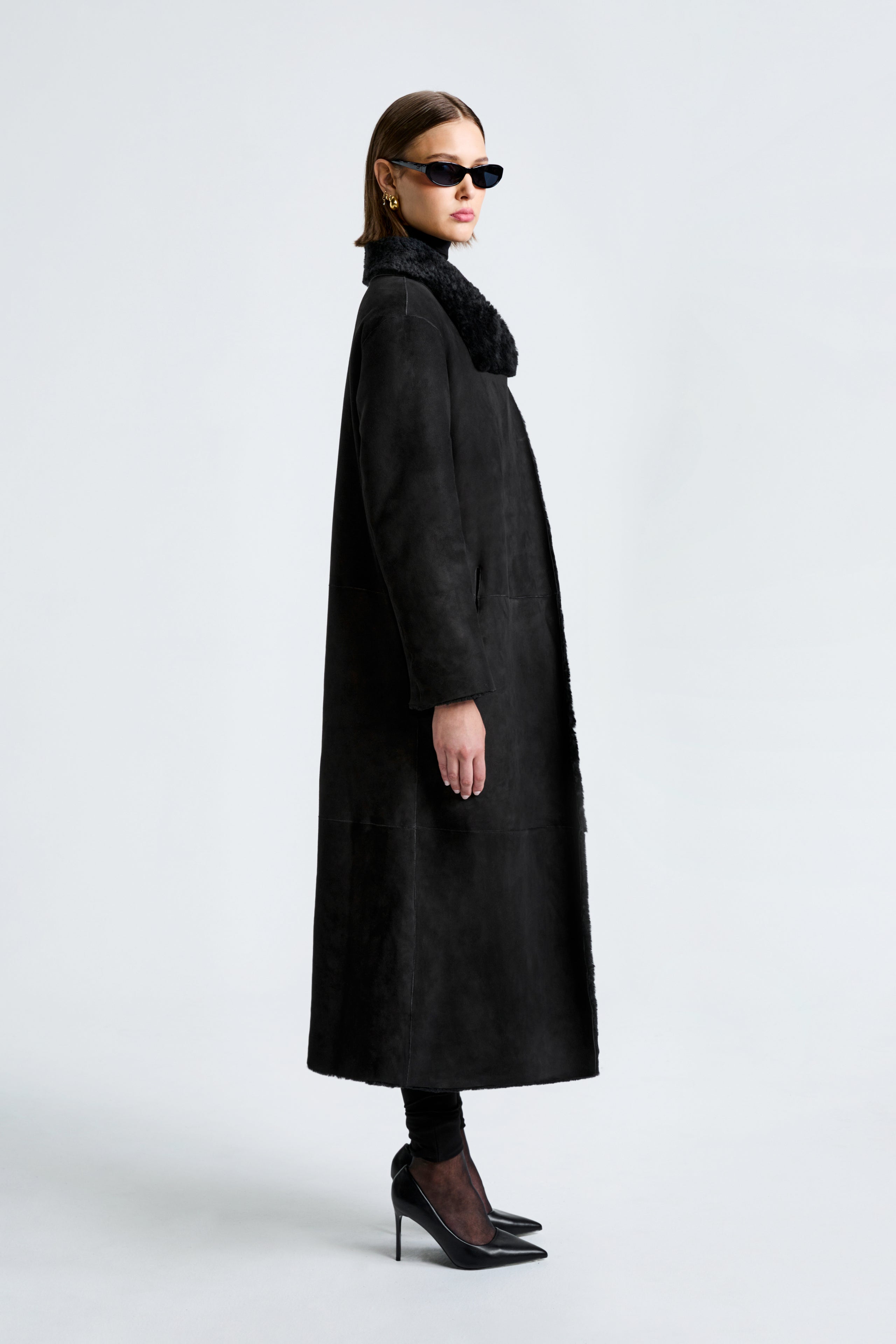 Model is wearing the Nour Hammour New Birthday Coat Black - Draped Shearling Coat - Side