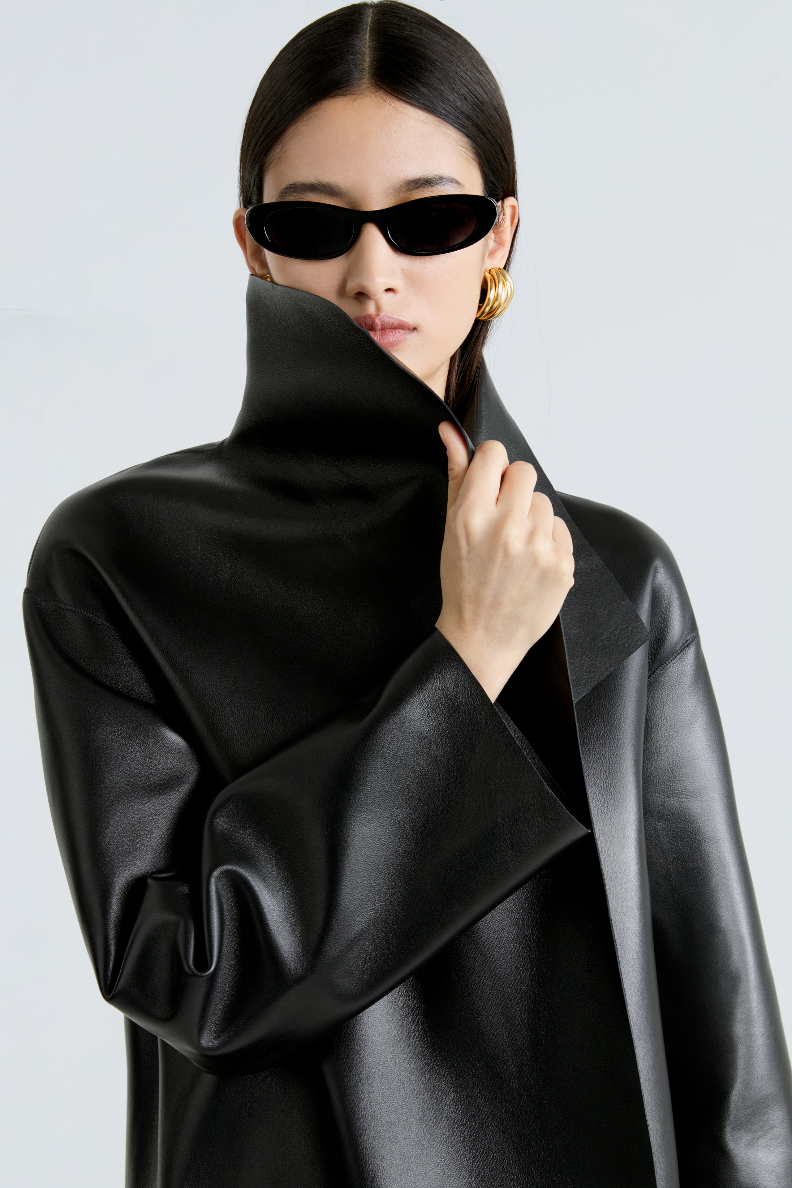 Model is wearing the Nour Hammour Birthday Coat Leather Black Draped Leather Coat Close Up