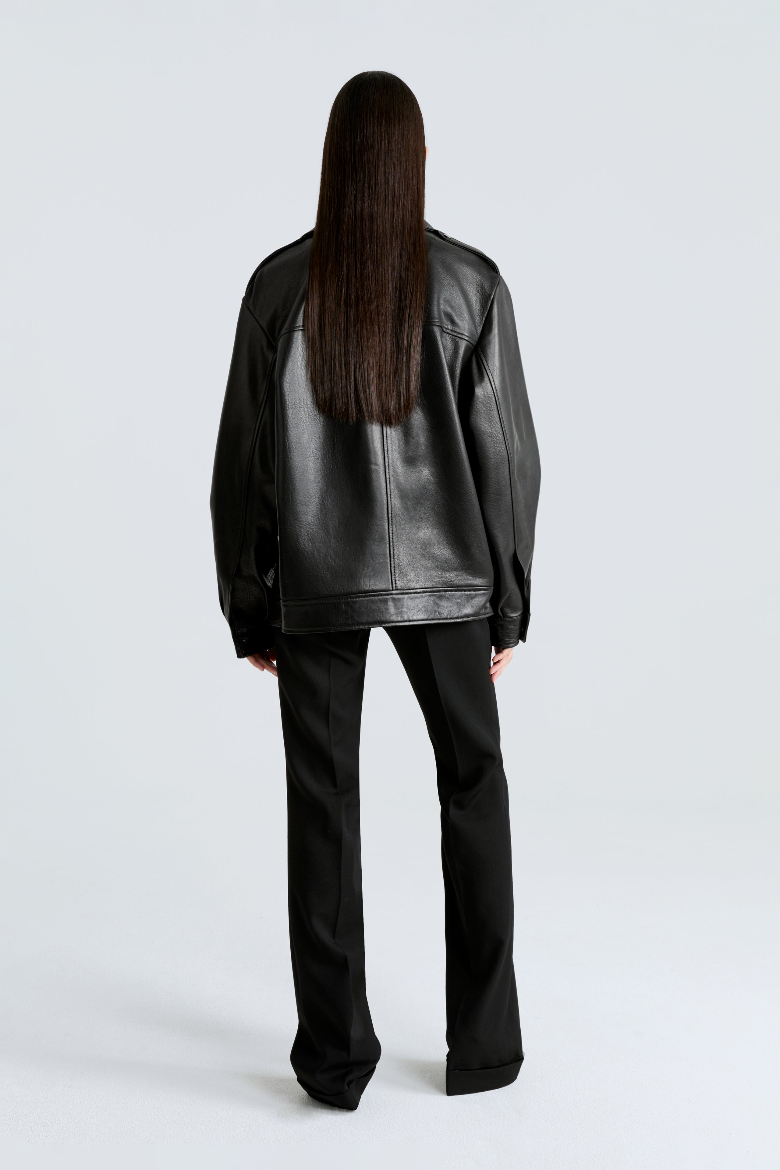 Model is wearing Nour Hammour's Drey Oversized Leather Jacket in black - Back