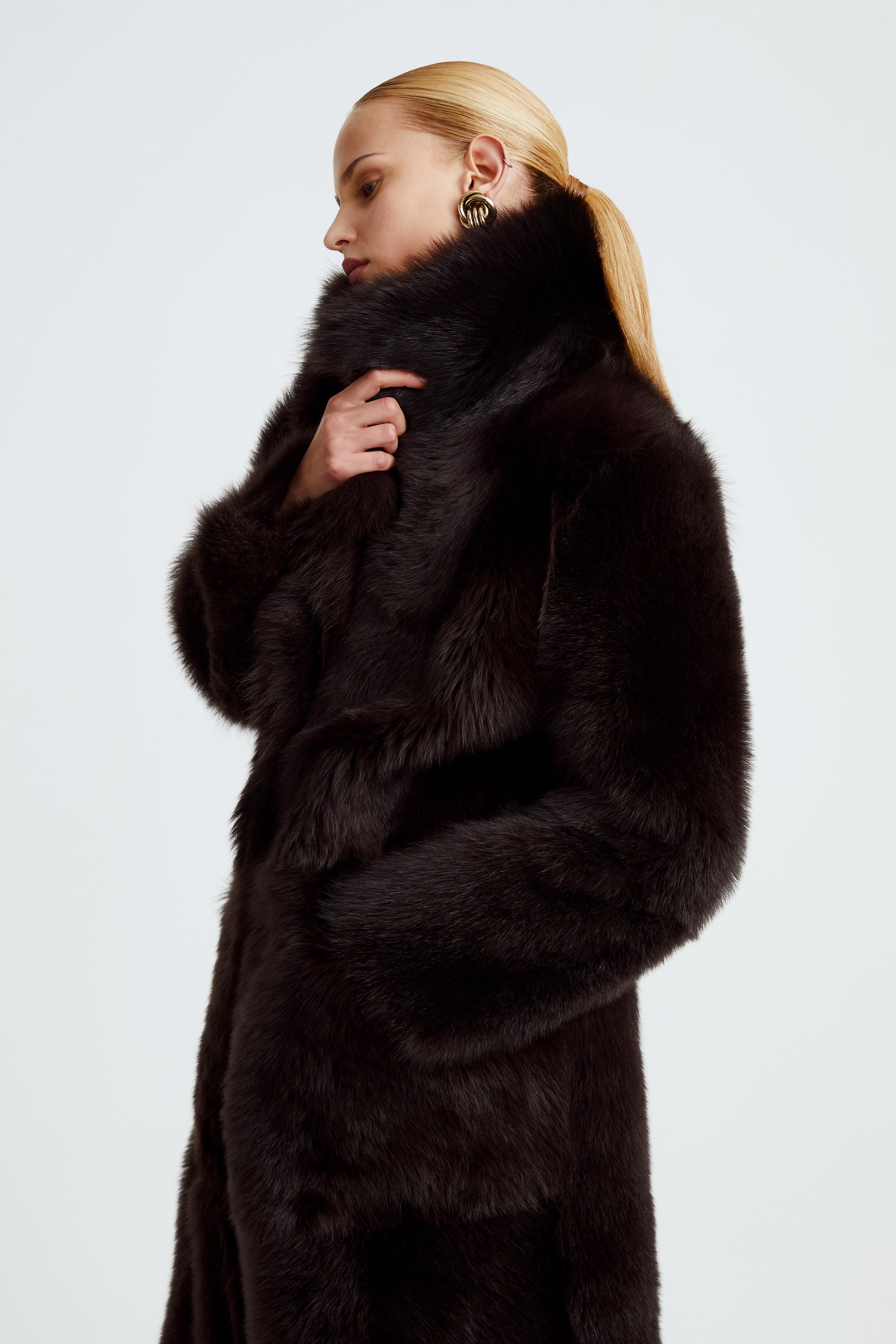 Model is wearing the Evita Chocolat Fondant Après-Ski Shearling Coat Close Up