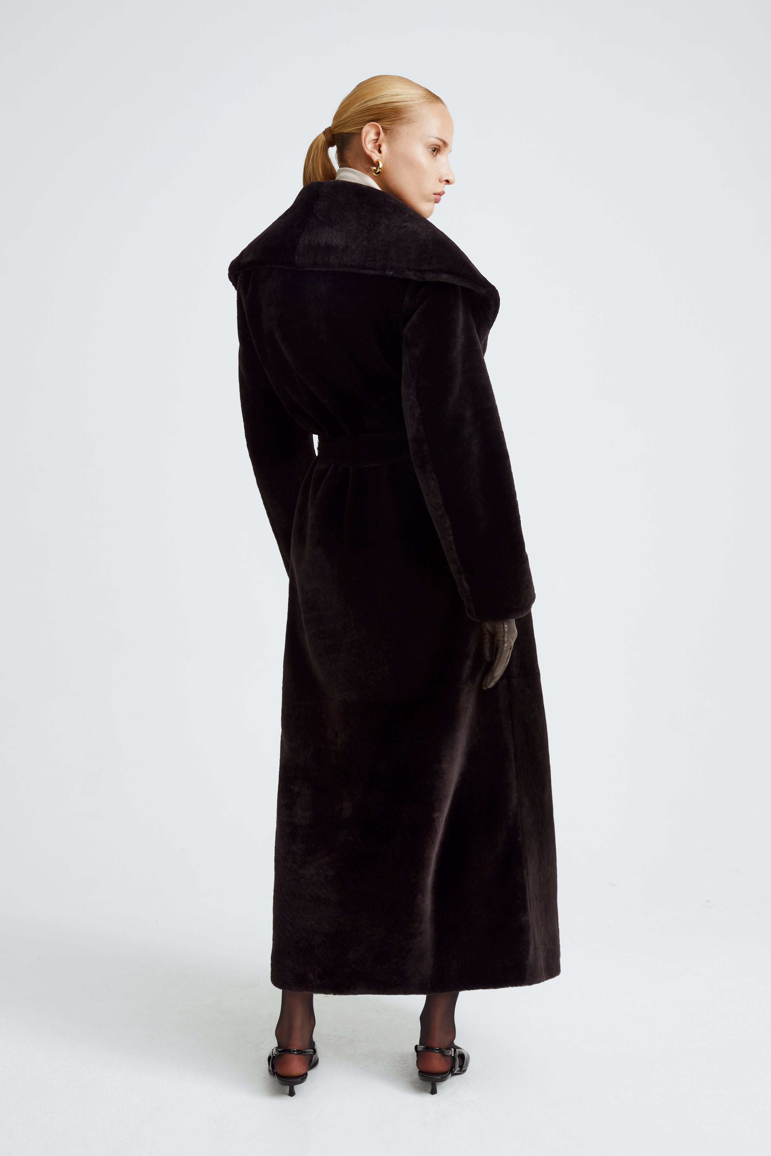 Model is wearing the Giovanna Chocolat Fondant Long Shearling Coat Back