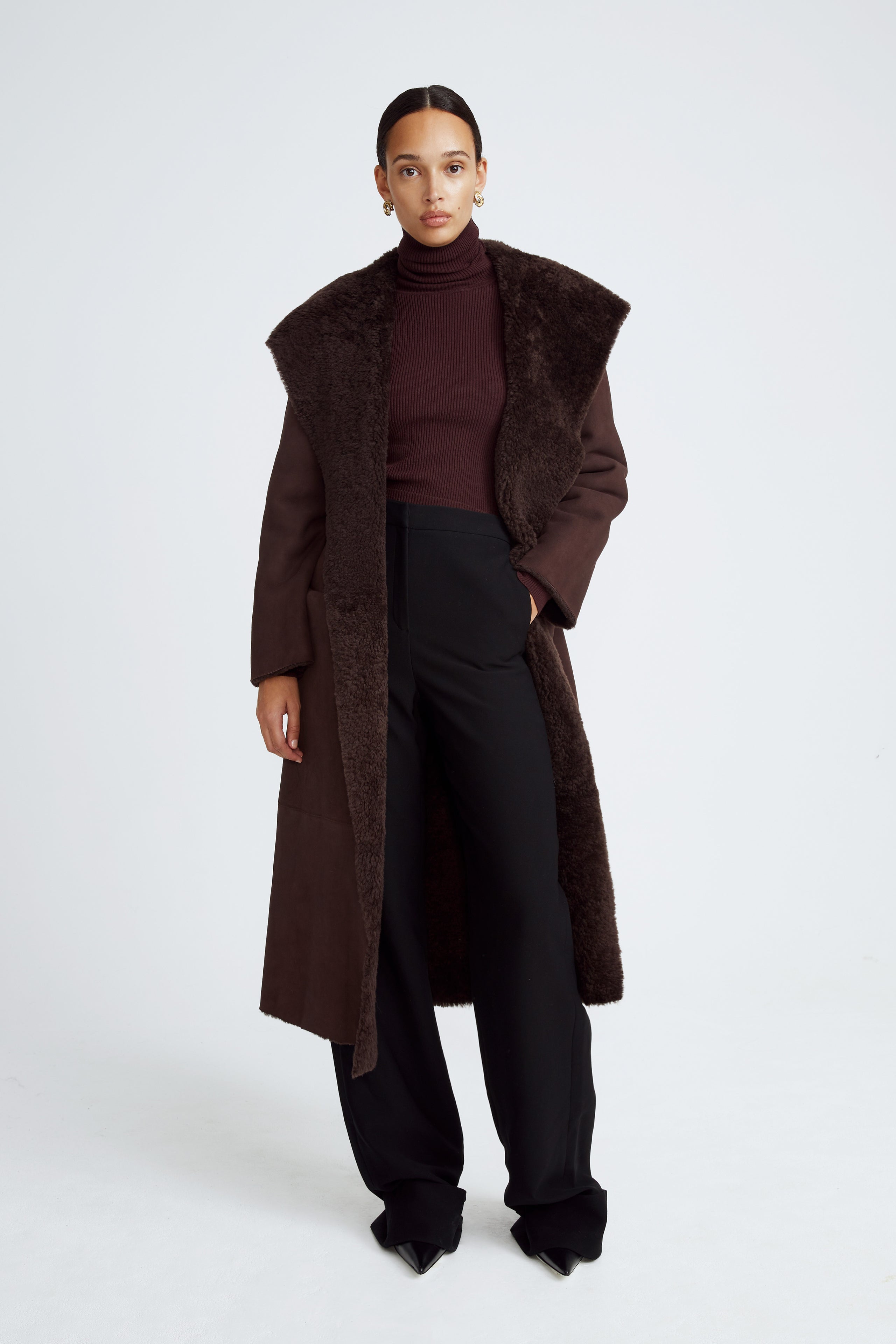 Model is wearing the Birthday Coat Dark Chocolate Draped Shearling Coat Front