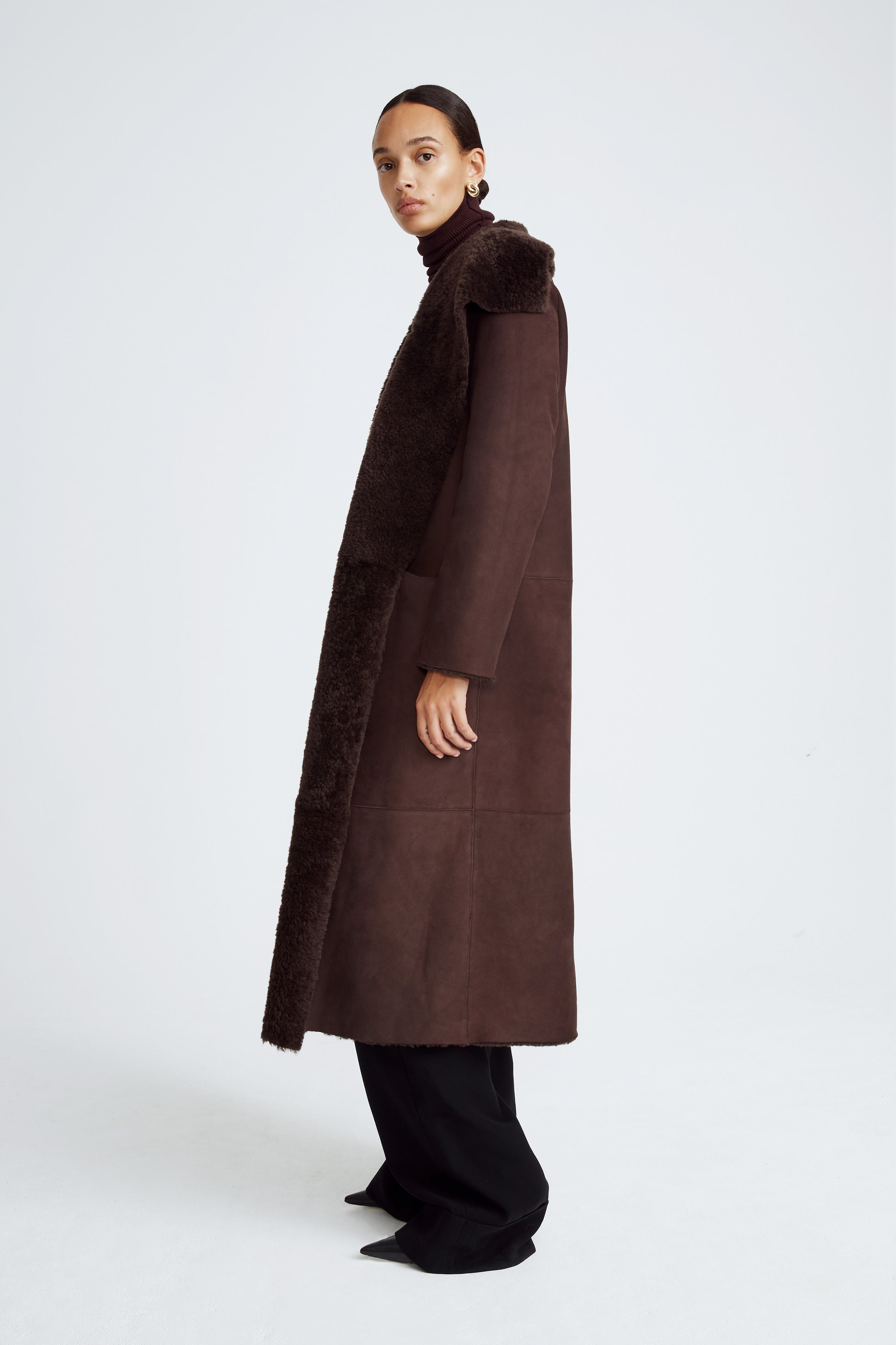 Model is wearing the Birthday Coat Dark Chocolate Draped Shearling Coat Side