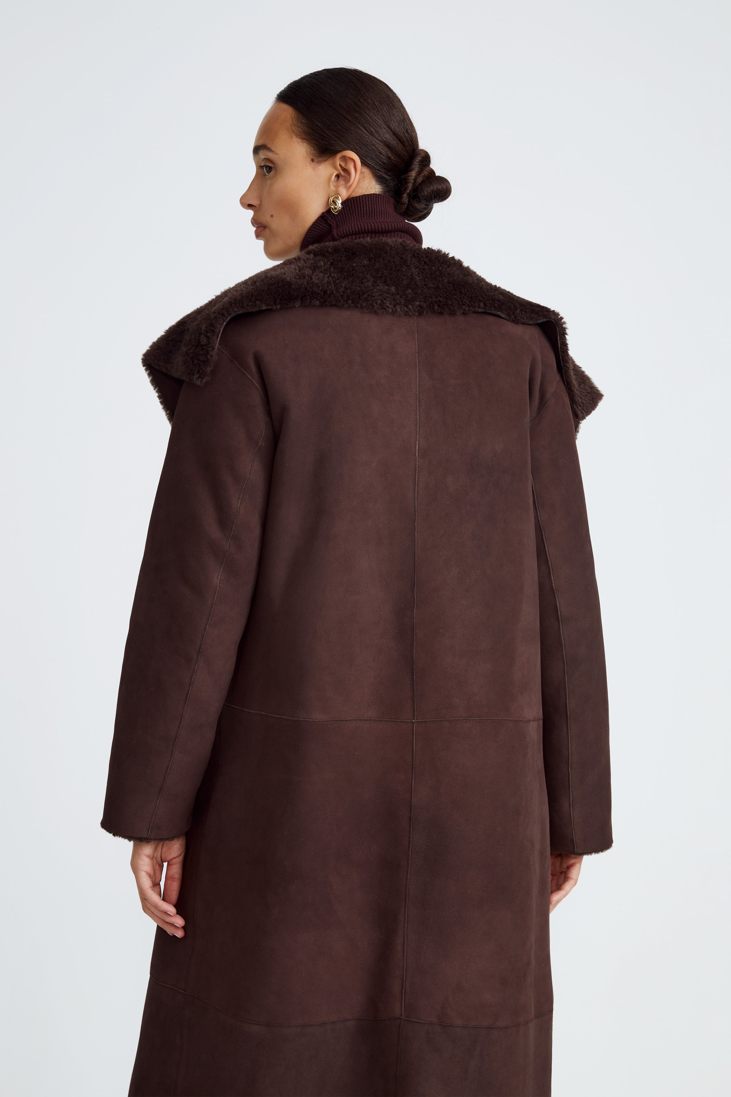Model is wearing the Birthday Coat Dark Chocolate Draped Shearling Coat Close Up
