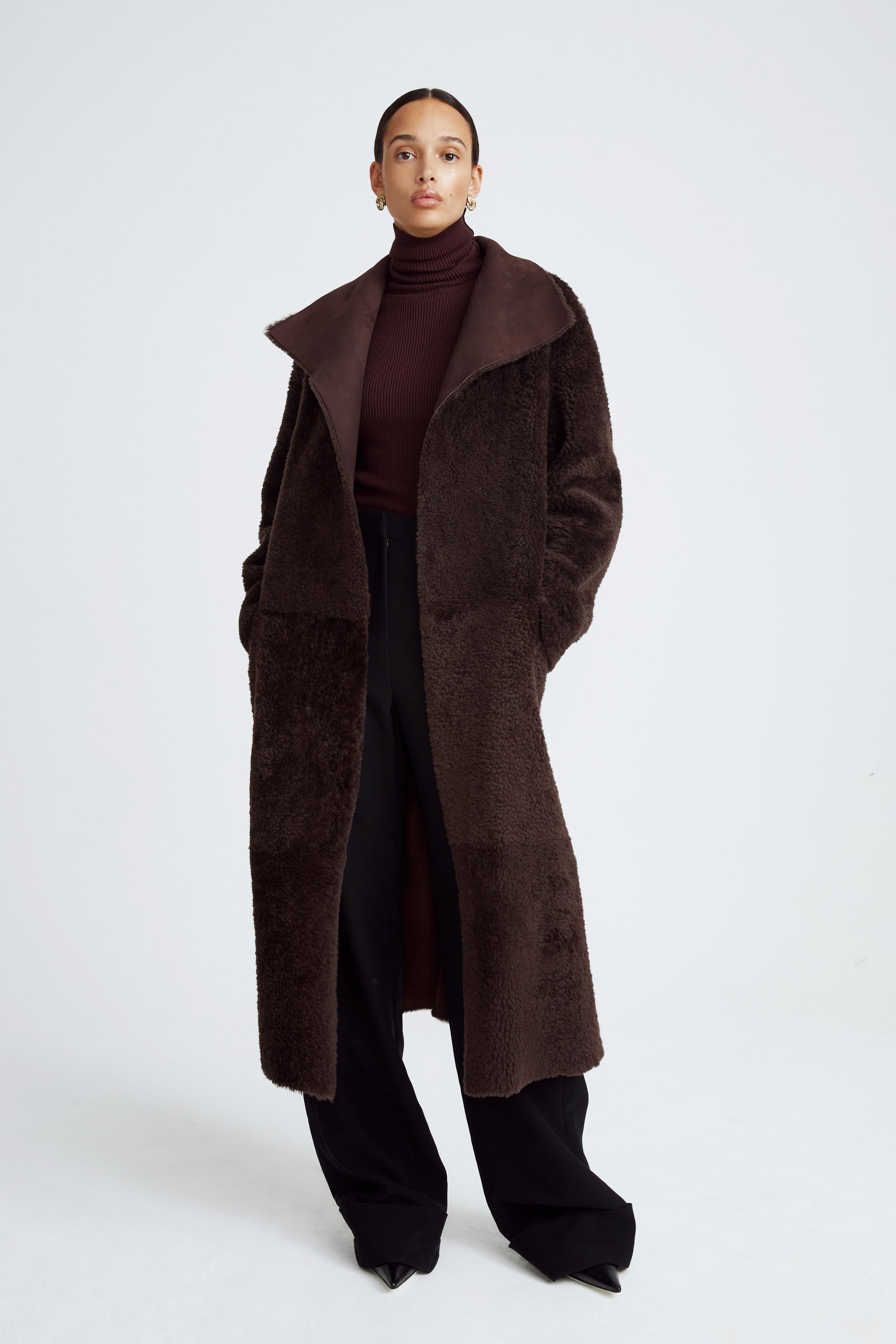 Model is wearing the Birthday Coat Dark Chocolate Draped Shearling Coat Front