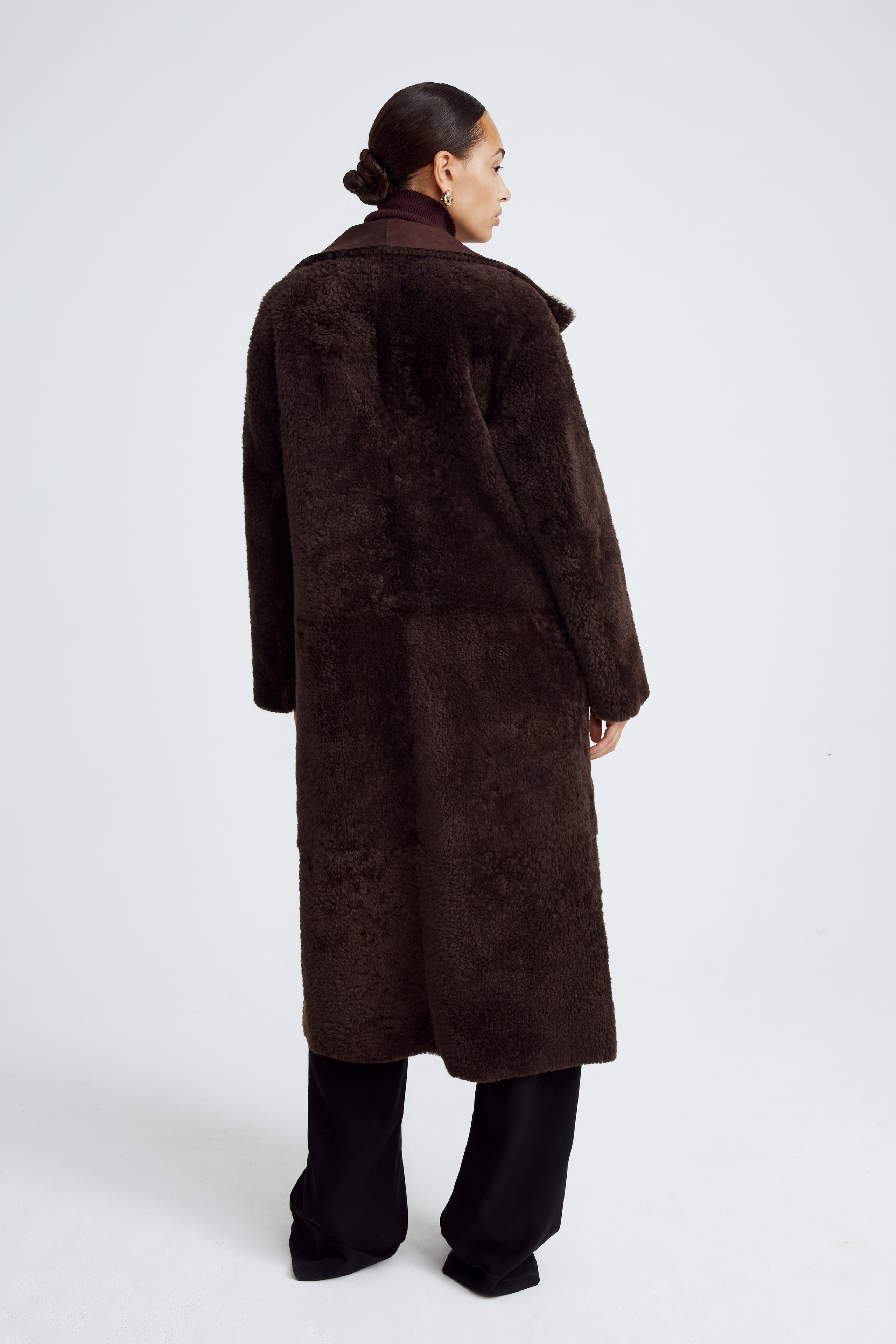 Model is wearing the Birthday Coat Dark Chocolate Draped Shearling Coat Back