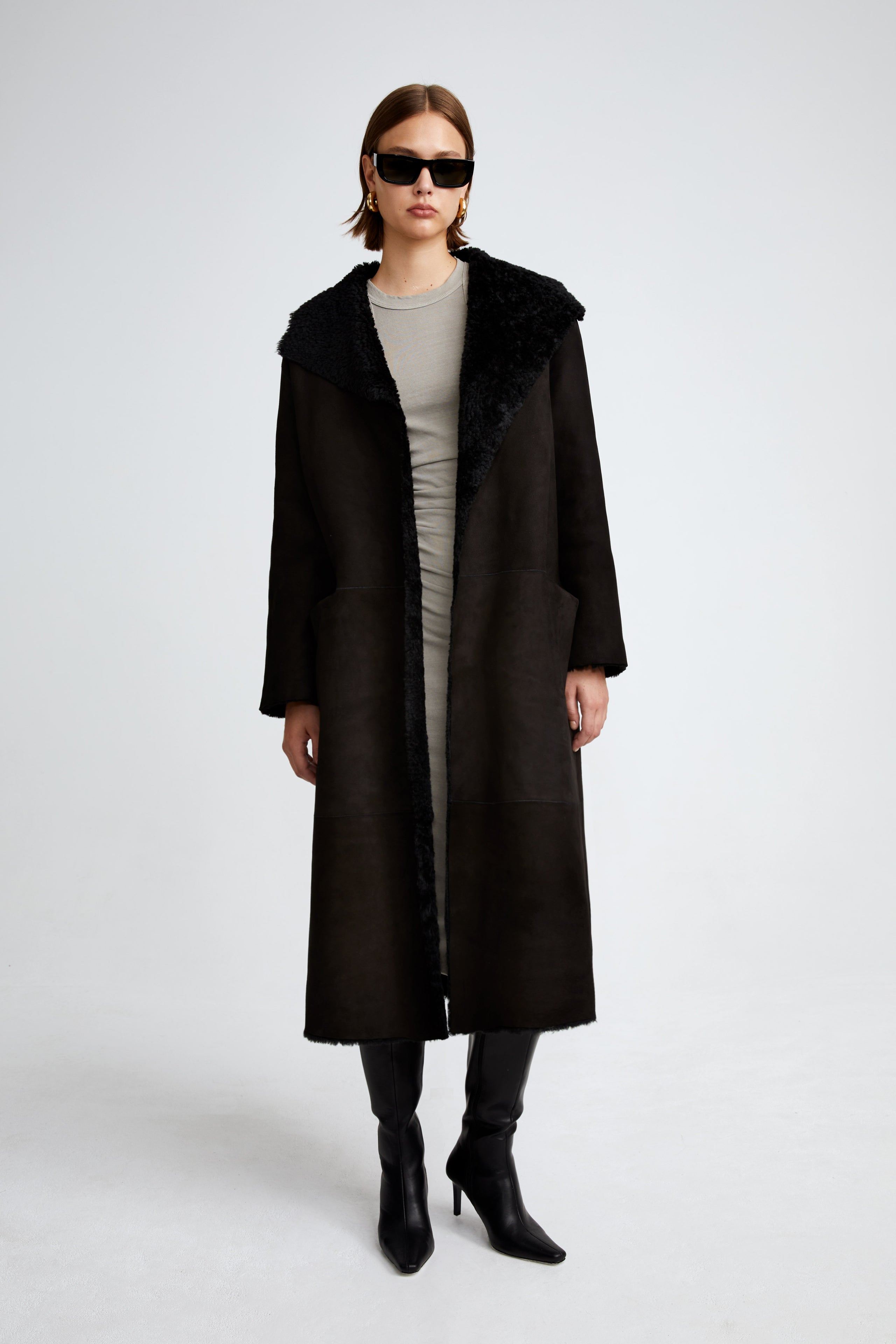 Model is wearing the Birthday Coat Black Draped Shearling Coat Front