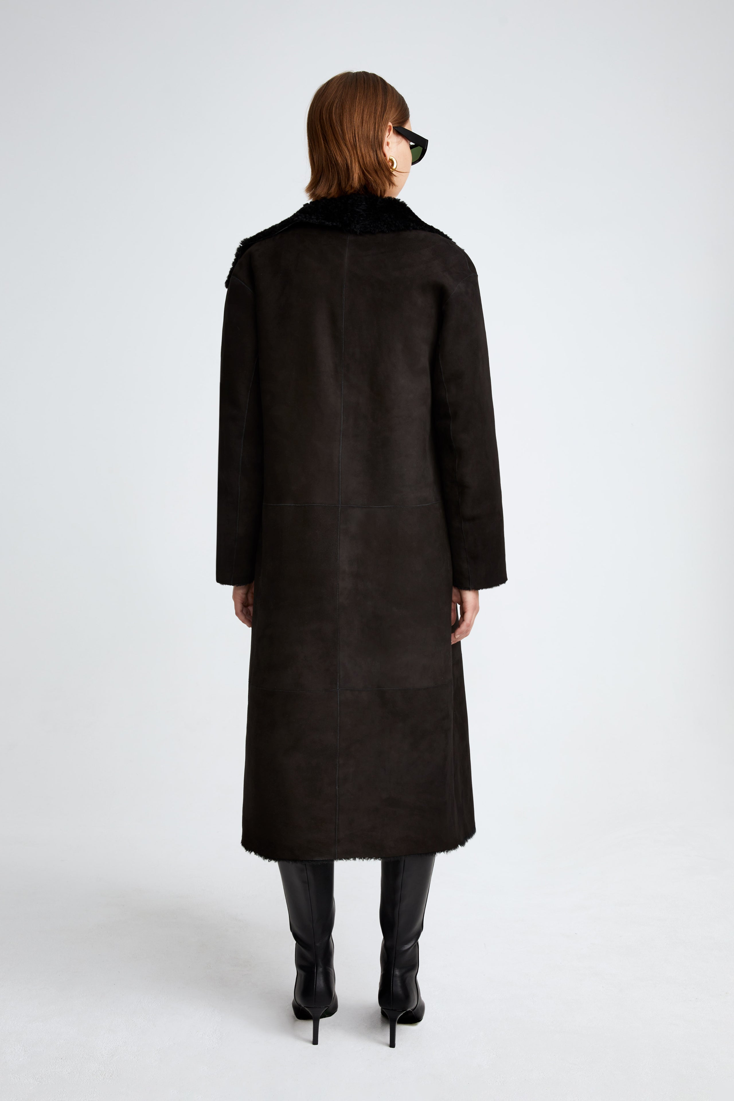 Model is wearing the Birthday Coat Black Draped Shearling Coat Back