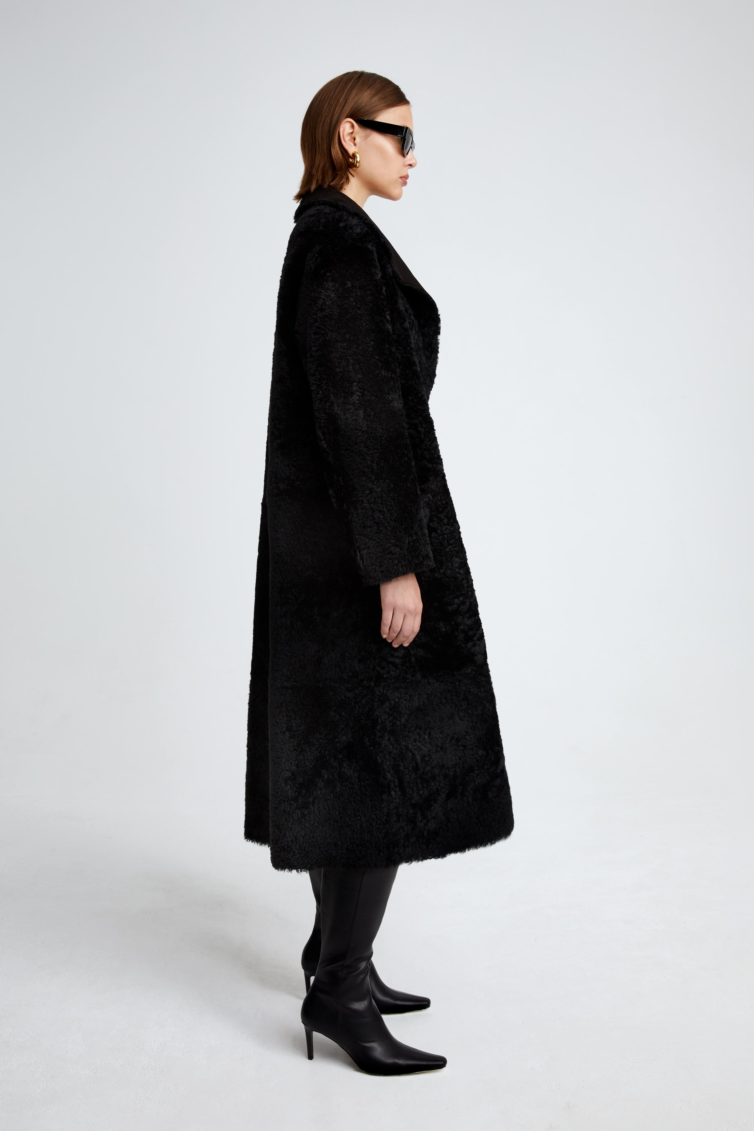 Model is wearing the Birthday Coat Black Draped Shearling Coat Side