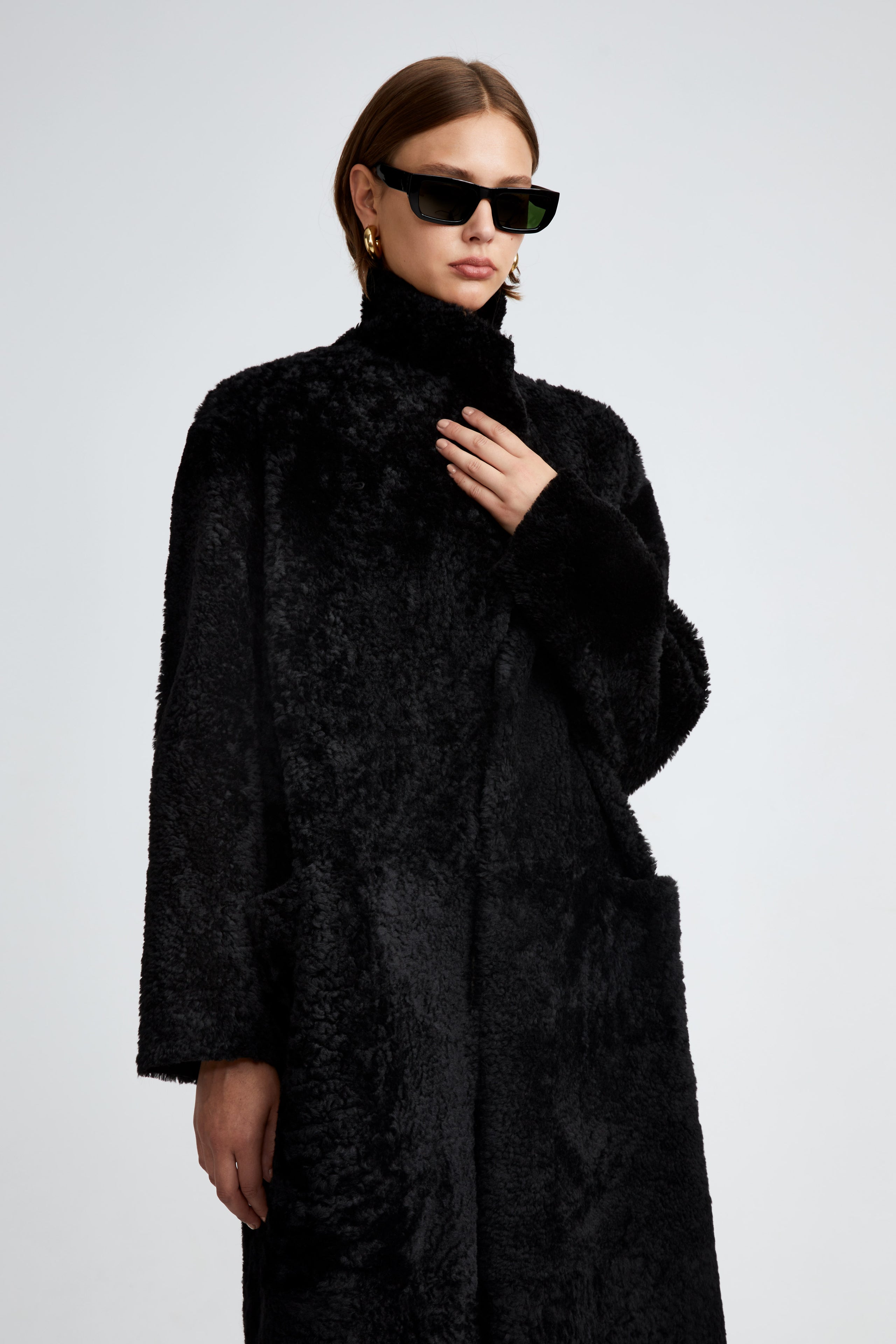 Model is wearing the Birthday Coat Black Draped Shearling Coat Close Up