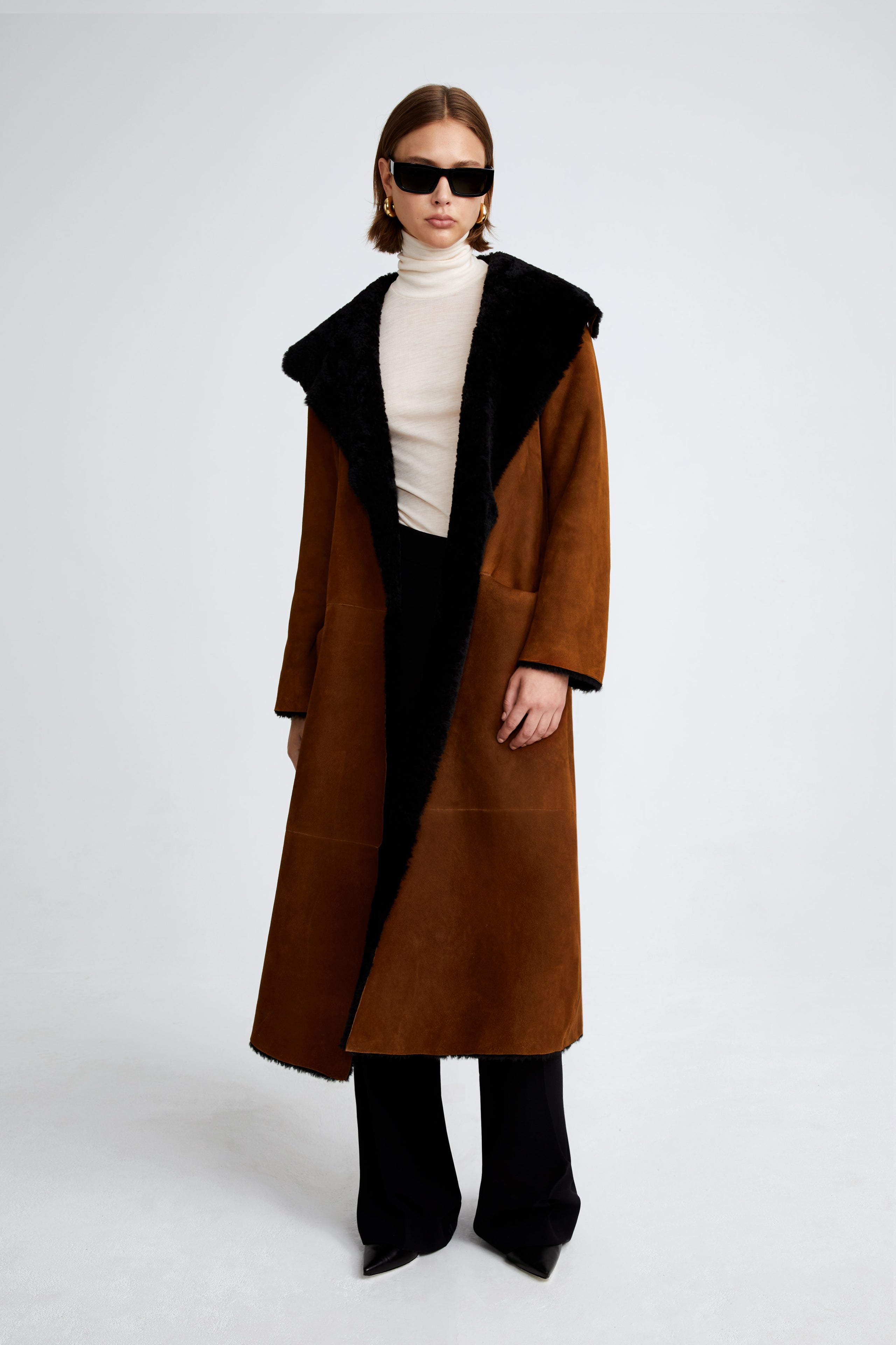 Model is wearing the Birthday Coat Cognac Black Draped Shearling Coat Front