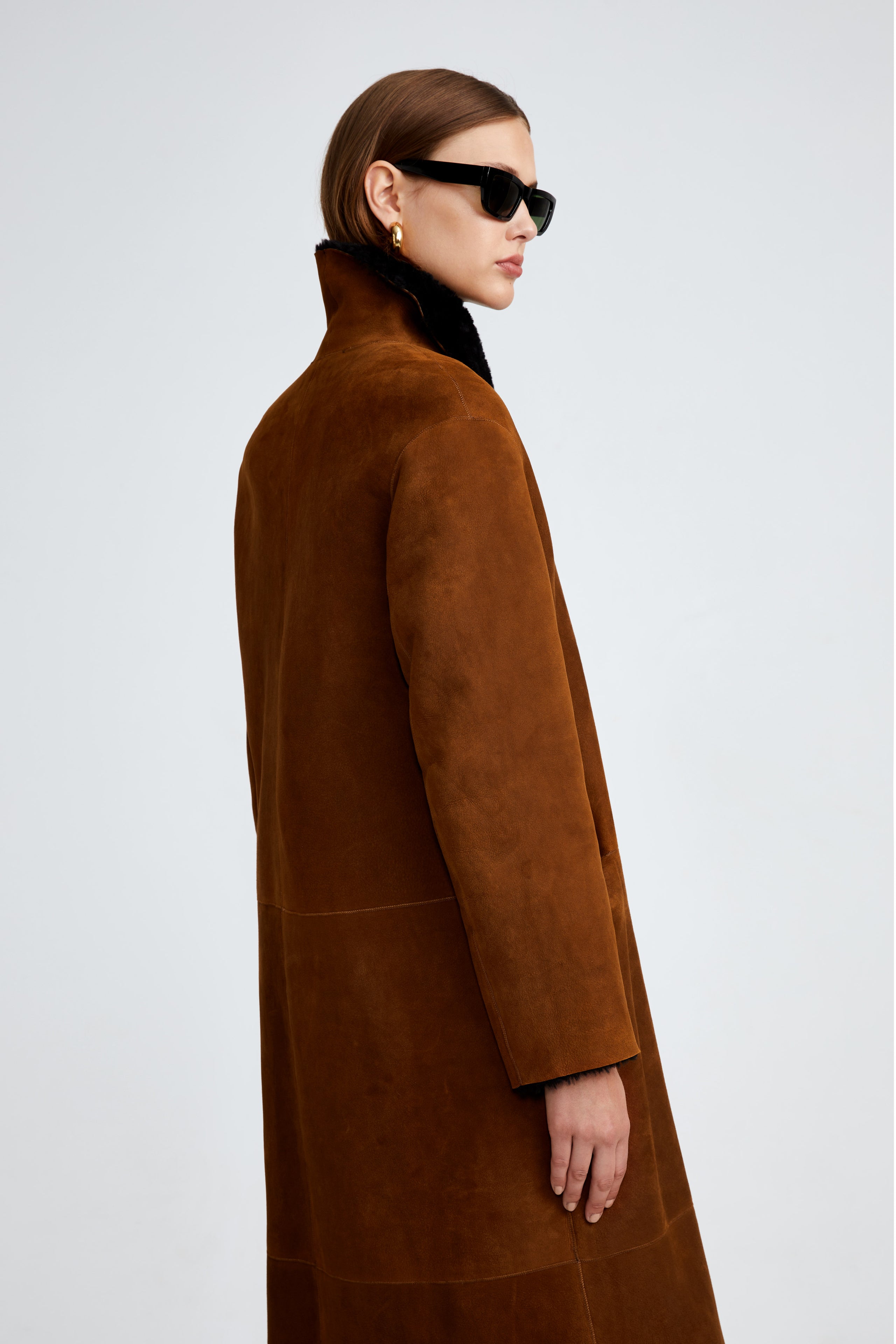 Model is wearing the Birthday Coat Cognac Black Draped Shearling Coat Close Up