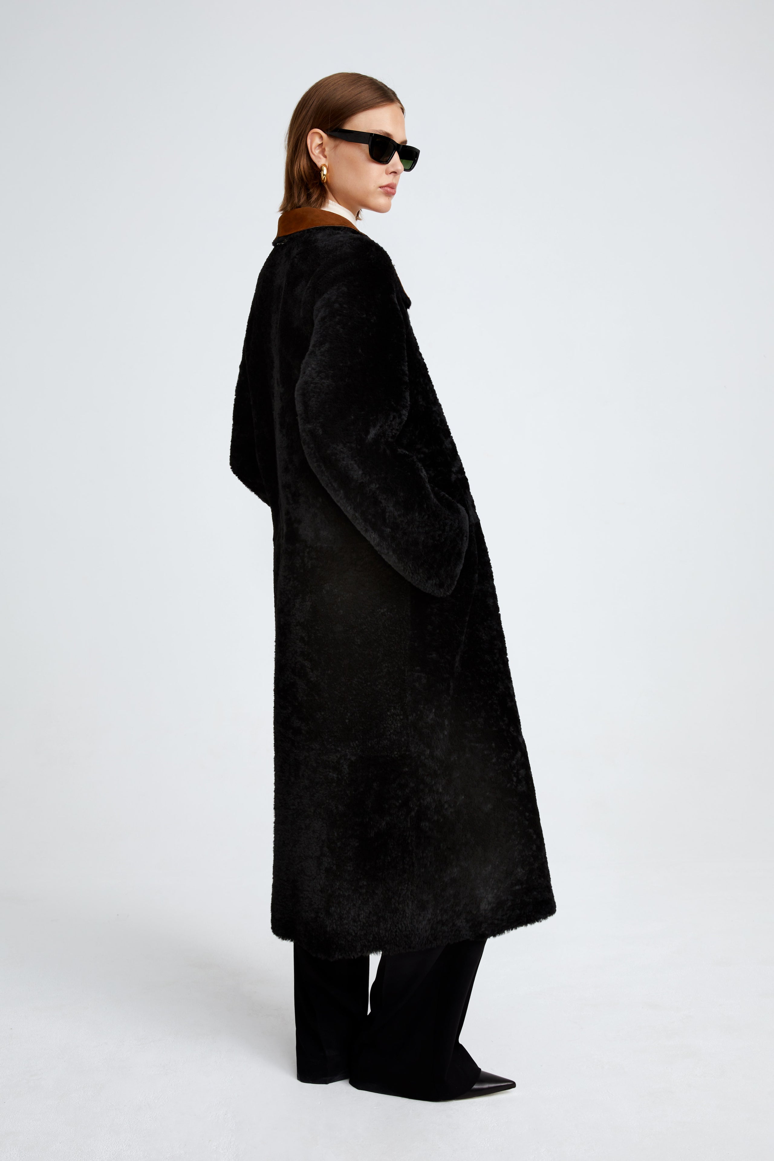 Model is wearing the Birthday Coat Cognac Black Draped Shearling Coat Side