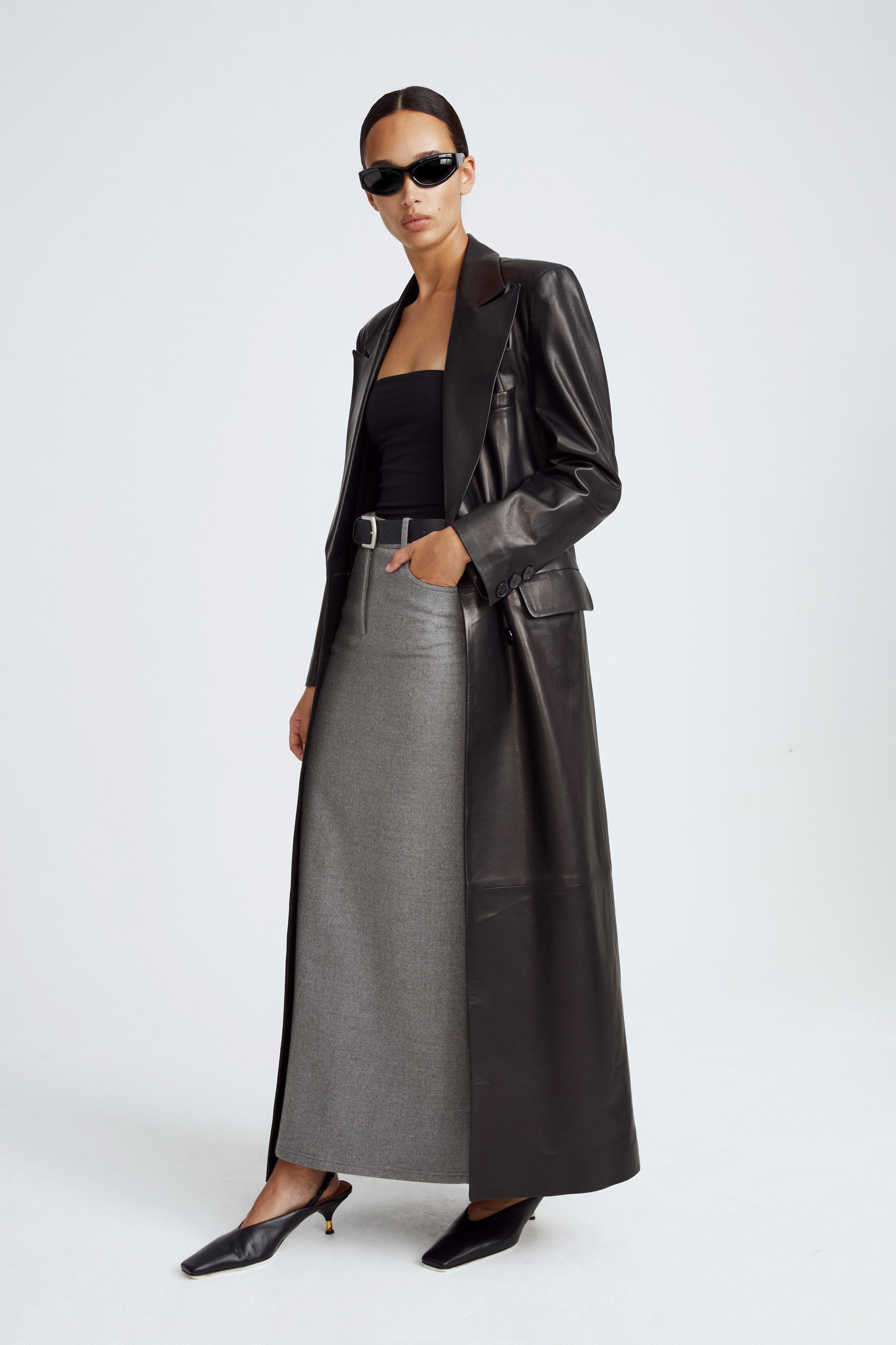 Model is wearing the Misha Black Long Leather Coat Side