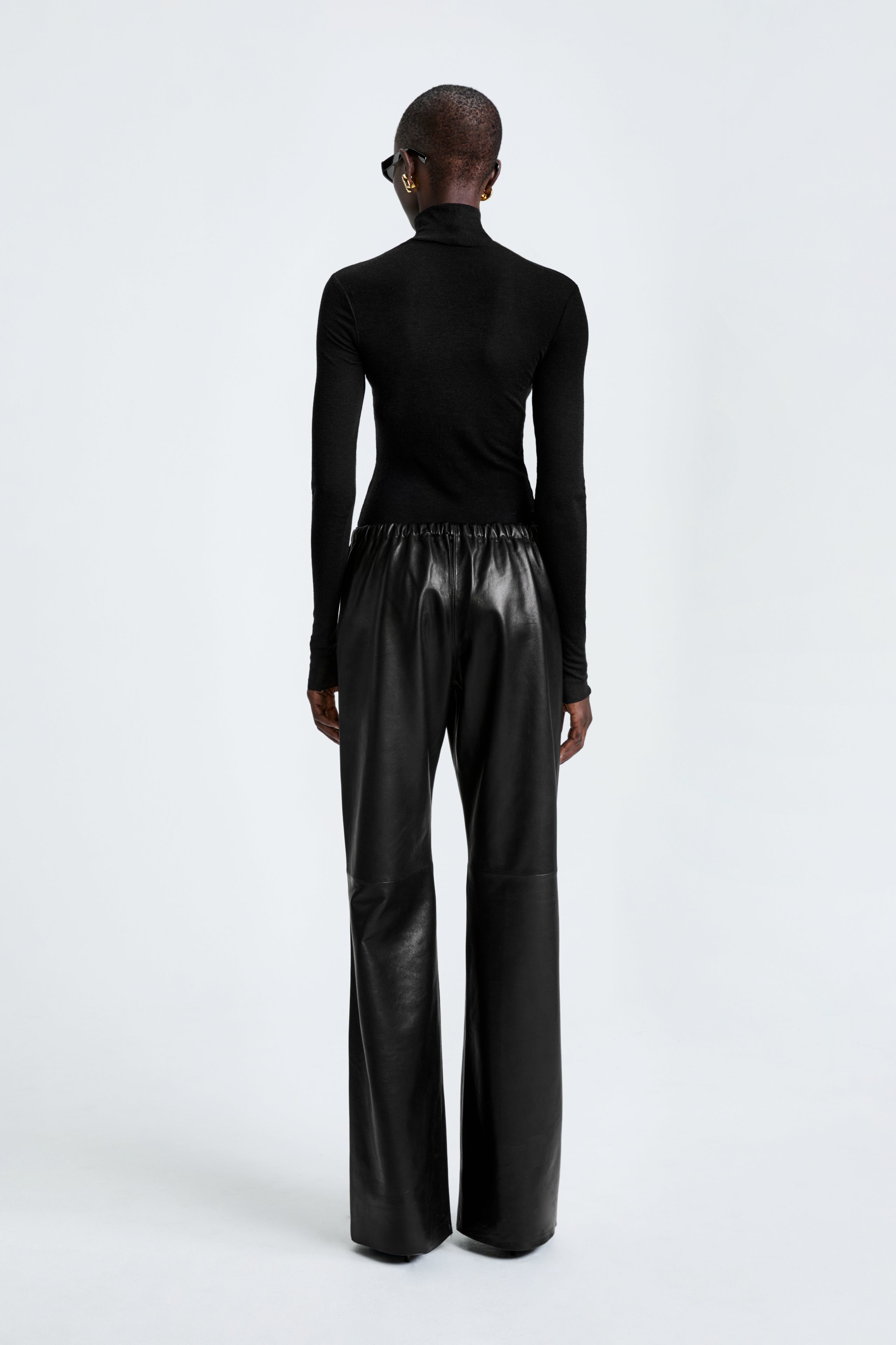 Model is wearing the Nour Hammour Olan Pants Black - Sleek Leather Pants - Back