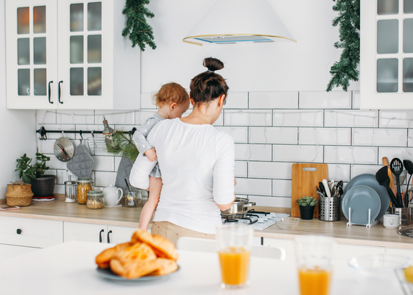 Mum in kitchen cooking with baby