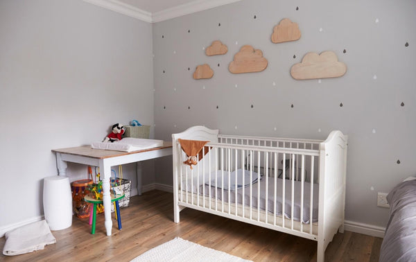 Well decorated baby nursery with white cot