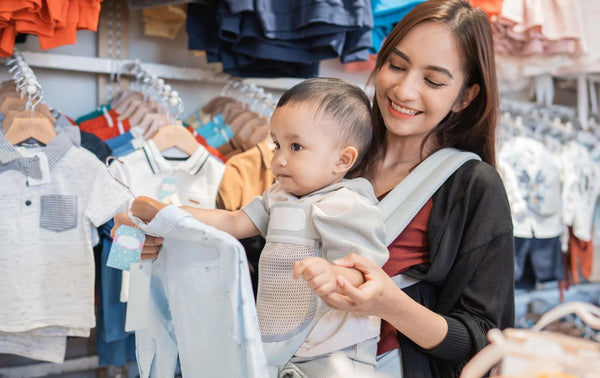 Mum shopping for baby clothes with her child