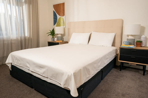 White waterproof flat sheet on a double bed