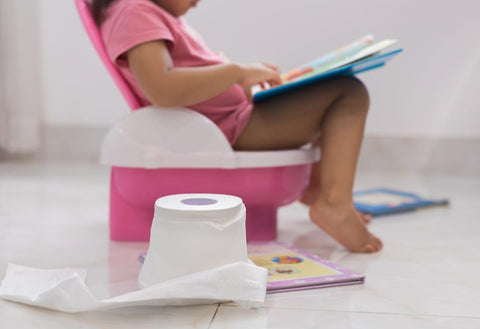 girl sitting on pink and white potty