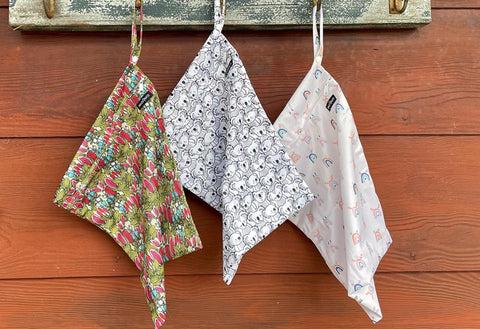 wet bags in multiple patterns hanging up on outside wall