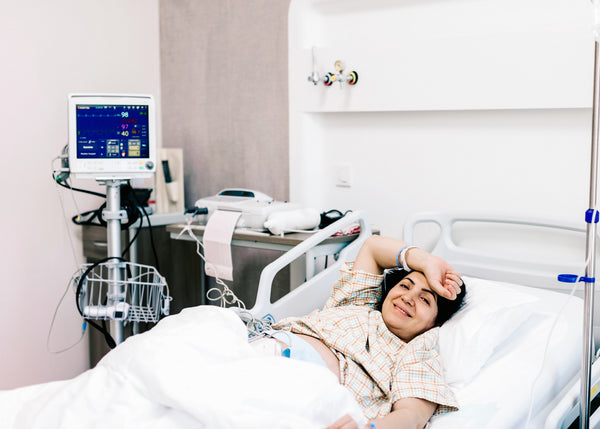 A mum lying in hospital bed after her Caesarean