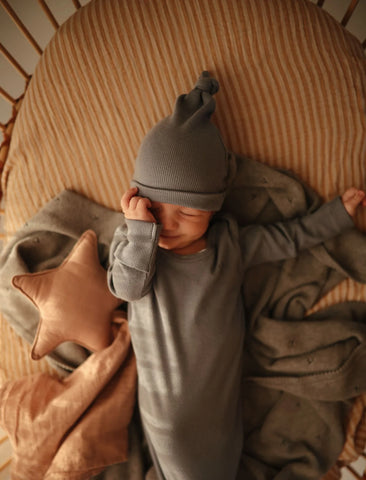 A Baby sleeping with wearing Mushie Ribbed Baby Beanie -ANB Baby