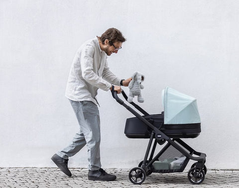 A man rolling Thule Shine City Stroller on the road -ANB Baby