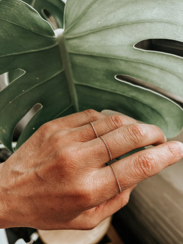 Hand with permanent rings made of a thin gold chain by Camillette Jewelry