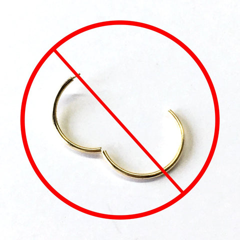 A hoop earring opened too much inside a crossed out red circle sign to show a wrong way to open them