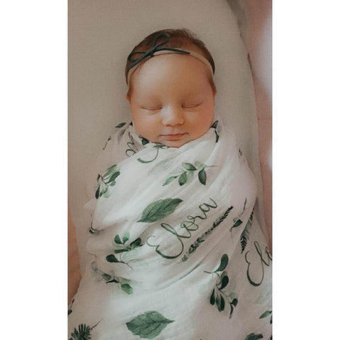 Baby wrapped in botanical swaddle