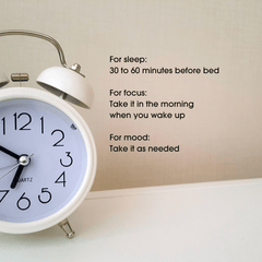 An analog alarm clock with text describing when to take L-theanine for sleep, focus and mood