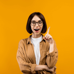 Woman in glasses having an aha moment in front of a yellow wall