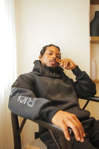 Leriq wears the Rich Mnisi Black Moon Hoodie