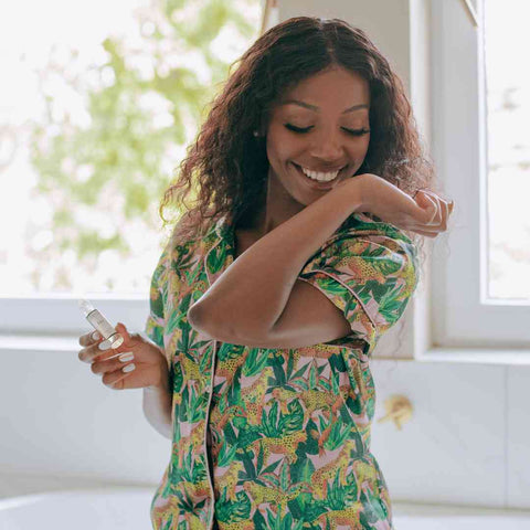Image of a woman spraying one of The Essence Vault perfume on their wrist, Why Do Women Put Perfume On Their Wrists and Ankles