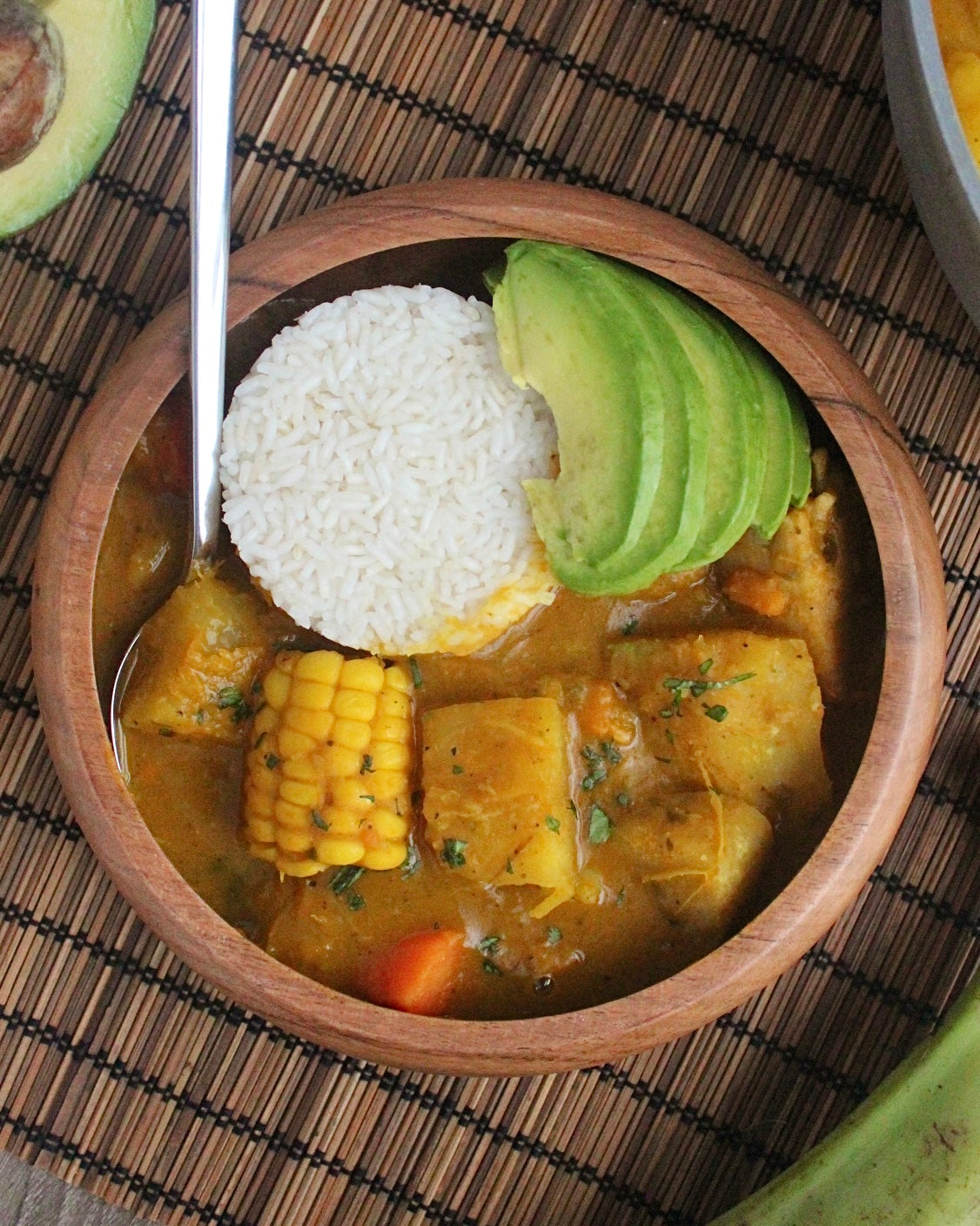 Vegan sancocho in a bowl with white rice and a spoon