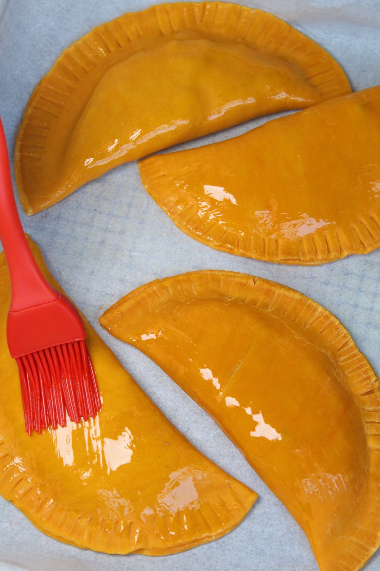 Adding oil to empanadas before baking