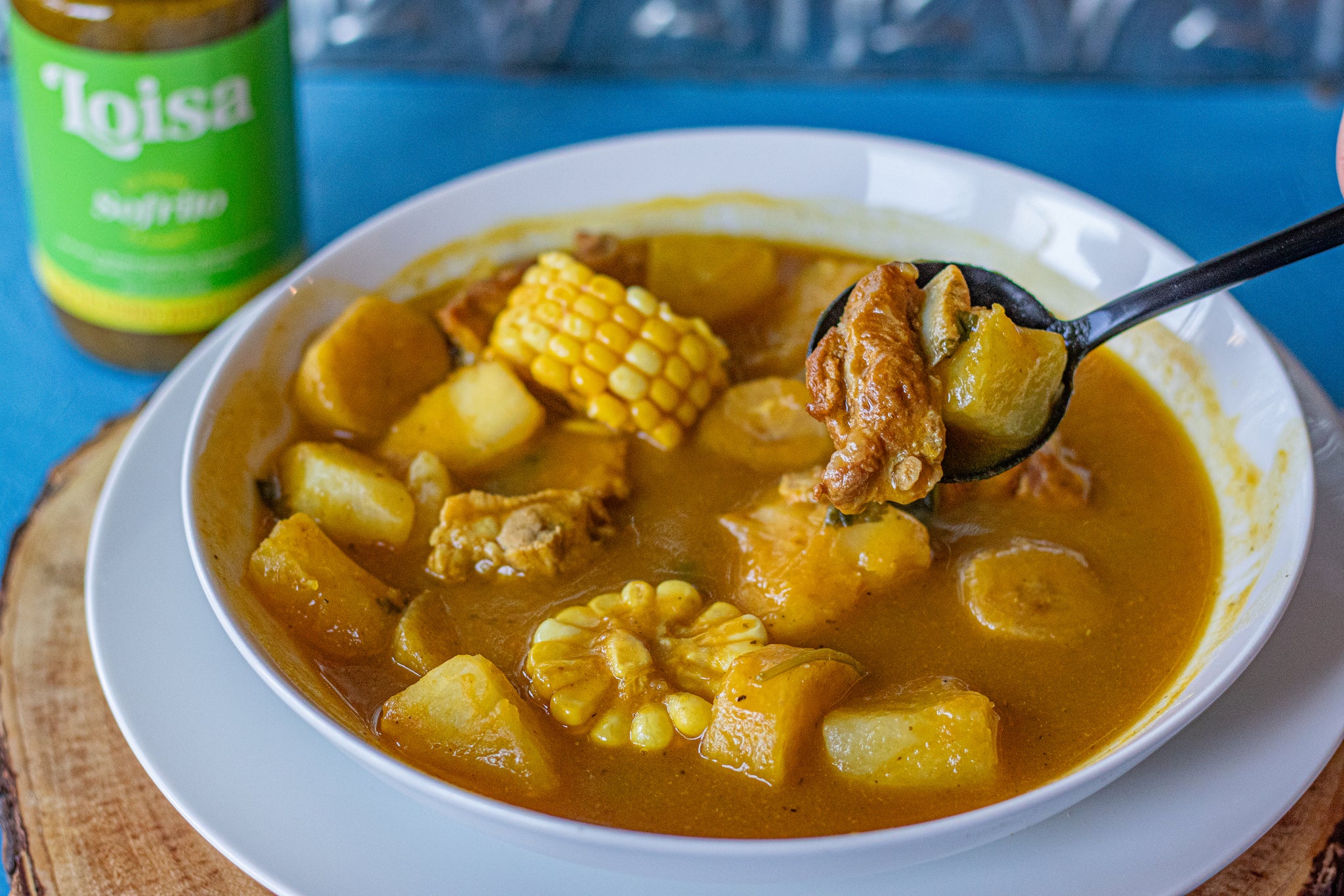 sancocho in a bowl with classic sofrito jar next to it