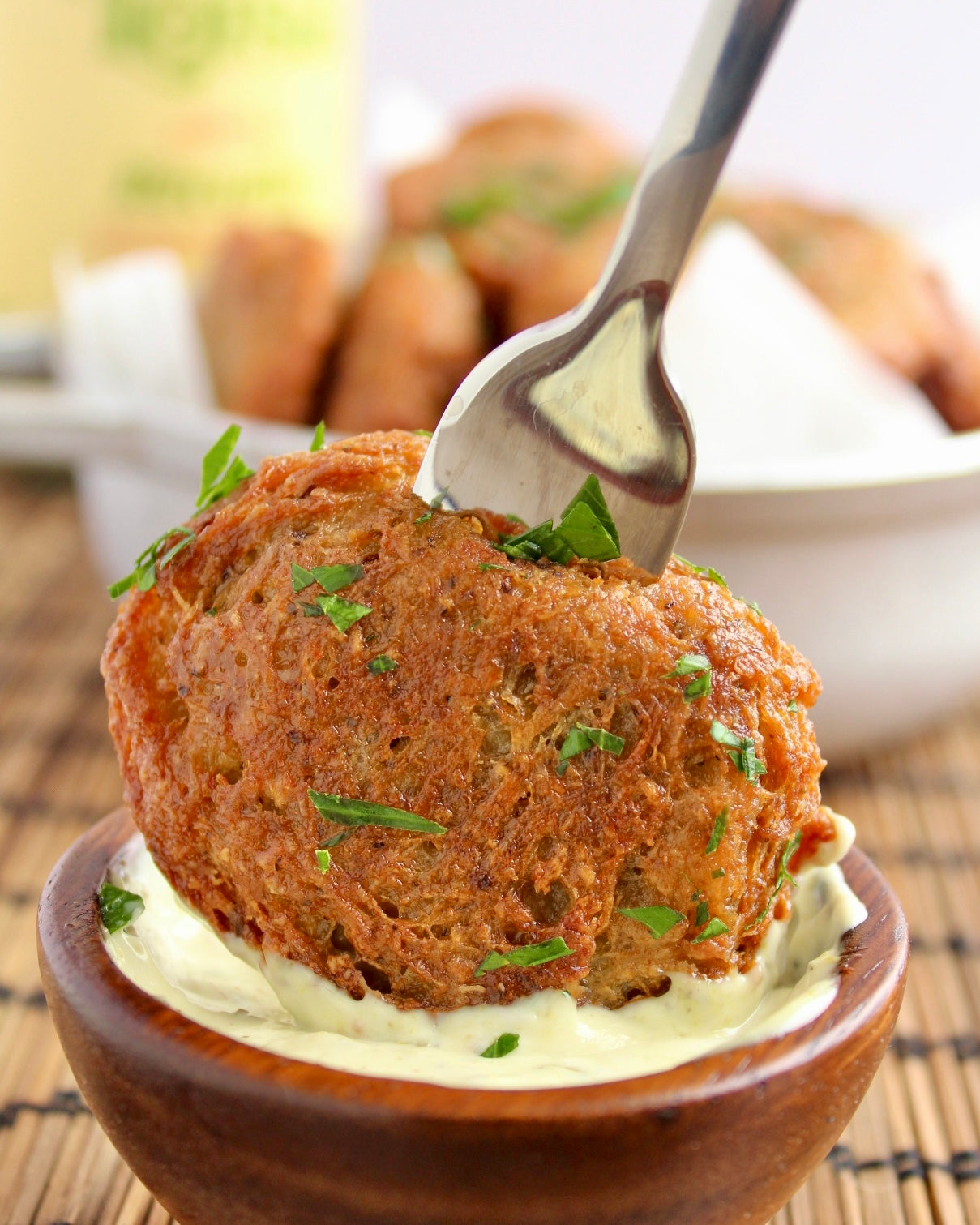 Dipping Malanga fritter in sauce with a fork