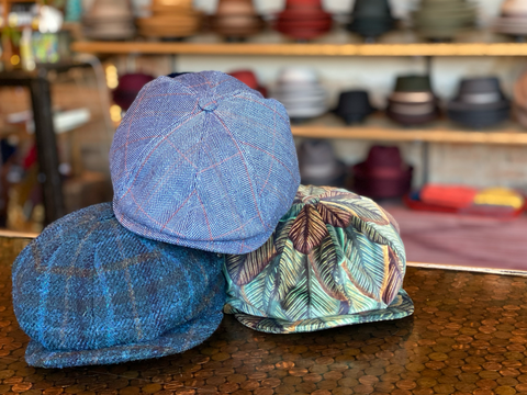 three patterned newsboy caps on a penny counter