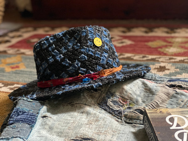 a beautifully textured black straw fedora with denim woven through it