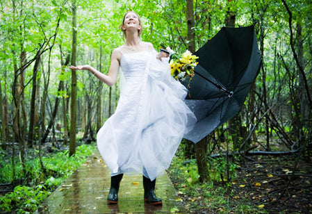 bride wearing rain boots at her rainy wedding