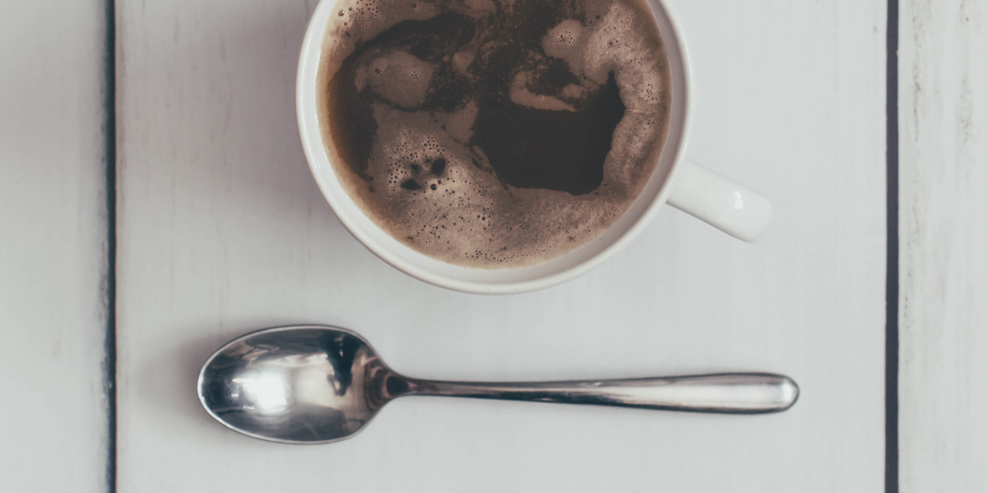 cup of coffee next to a spoon