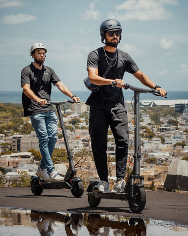 Two men joyfully riding electric scooters, exemplifying eco-conscious transportation and the fun of e-scooter commuting
